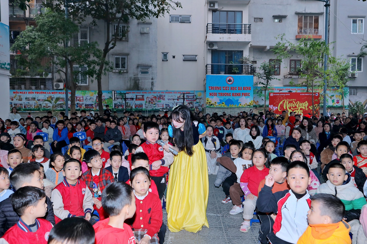 A person in a yellow dress standing in front of a group of children

Description automatically generated