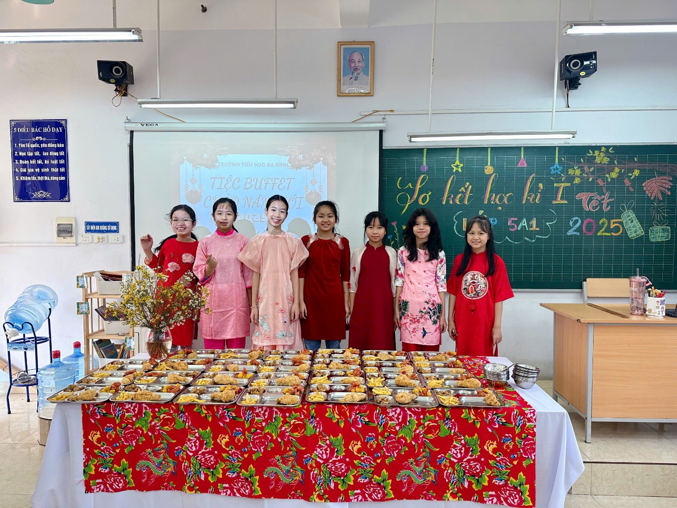 A group of girls standing in front of a table with food

Description automatically generated