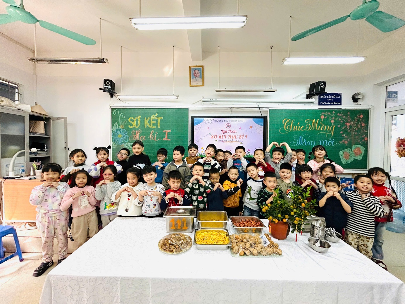 A group of children standing in front of a table with food

Description automatically generated