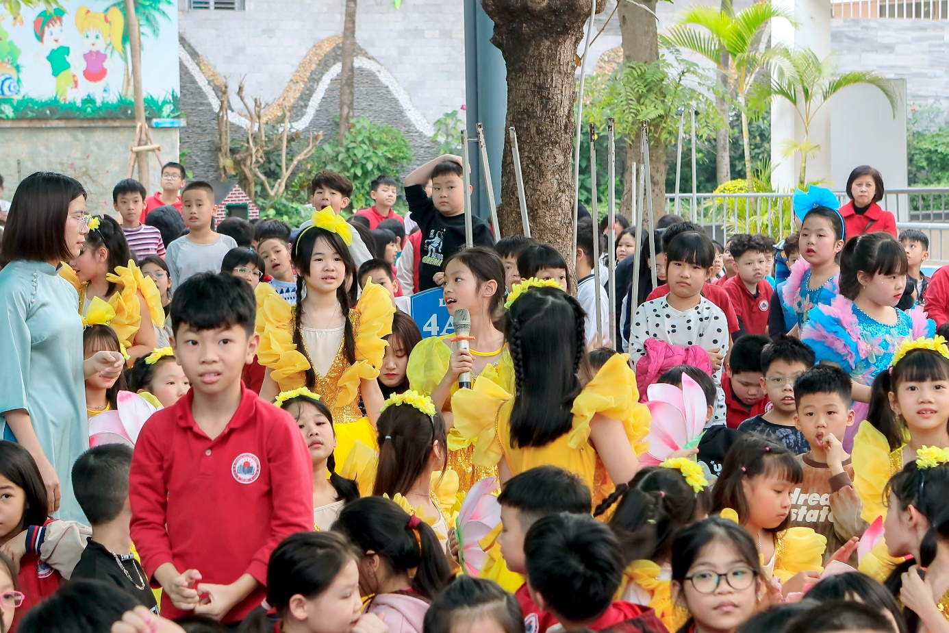 A group of children in yellow dresses

Description automatically generated