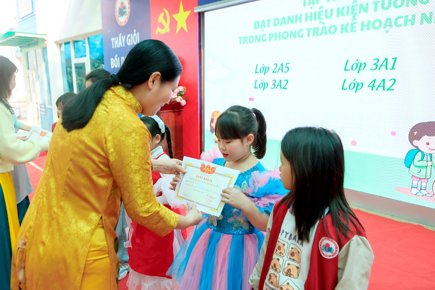 A person holding a certificate to a group of children

Description automatically generated