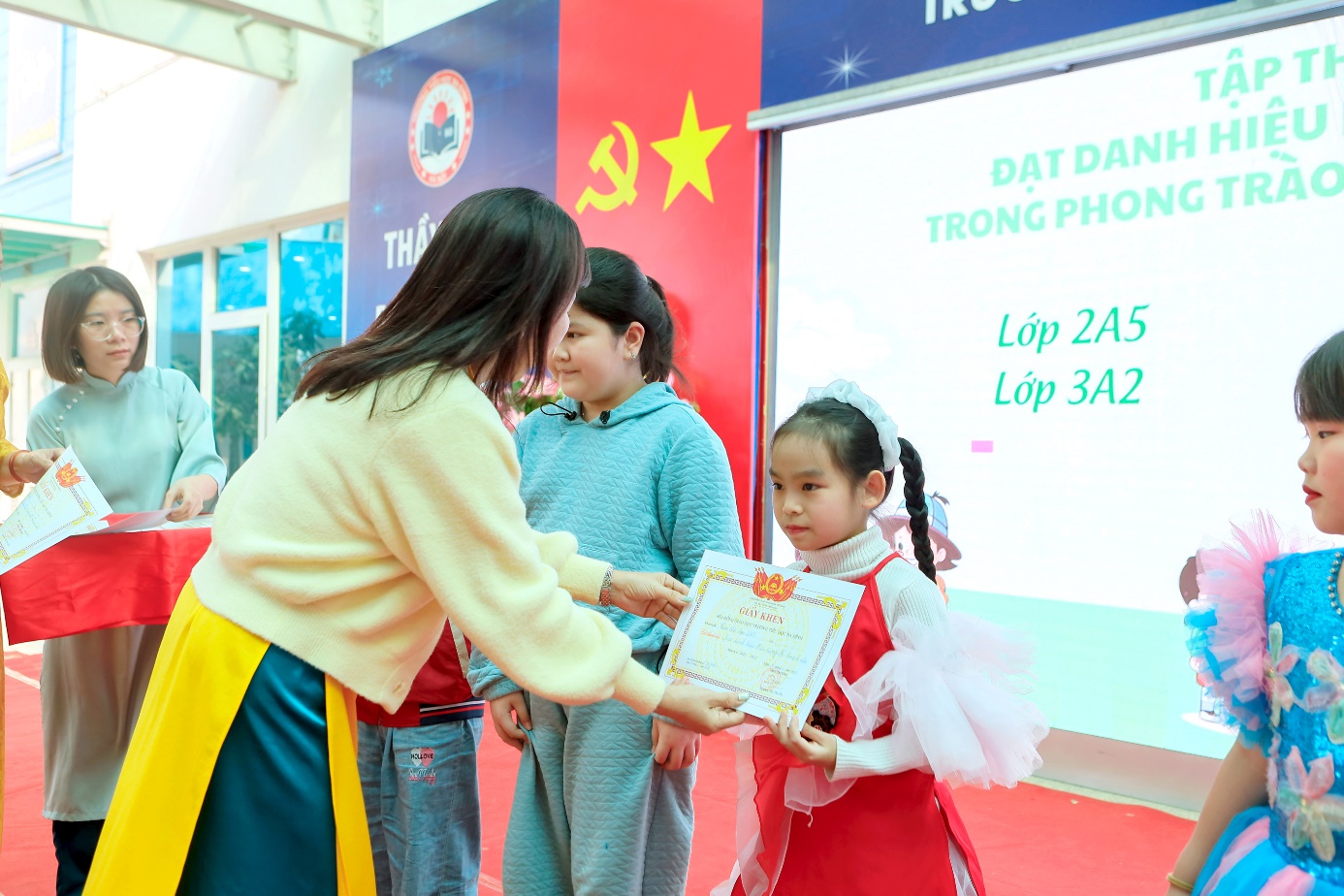 A person holding a certificate to a child

Description automatically generated