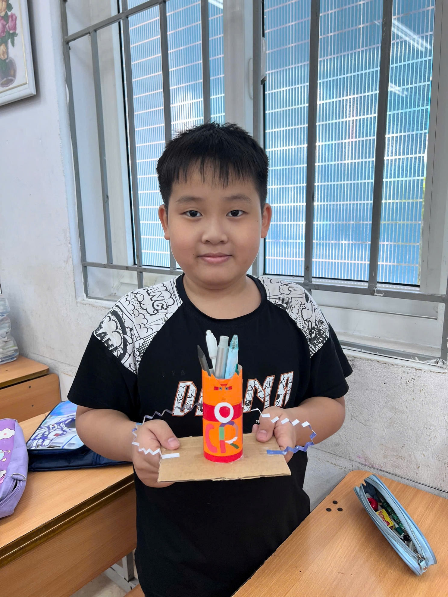 A child holding a cardboard box with pencils

AI-generated content may be incorrect.