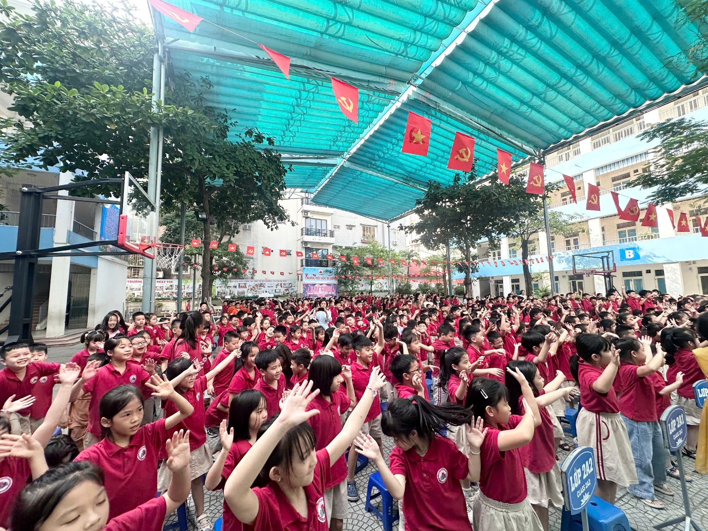 A group of children in red shirts raising their hands

AI-generated content may be incorrect.