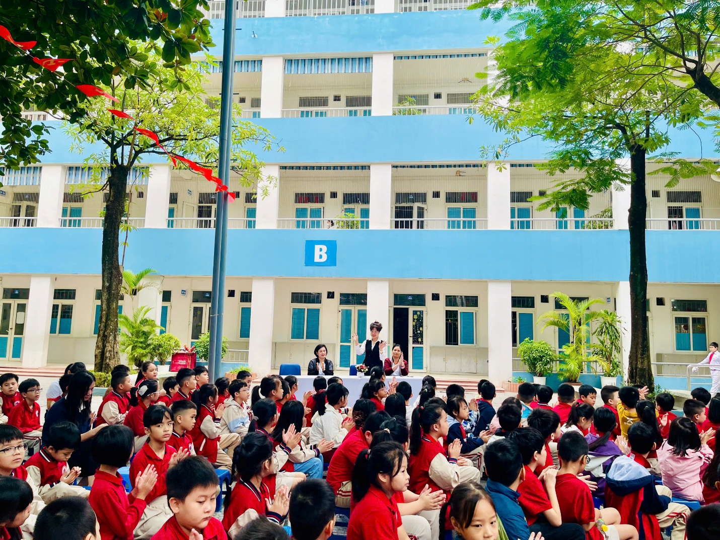 A group of children sitting in a courtyard

AI-generated content may be incorrect.