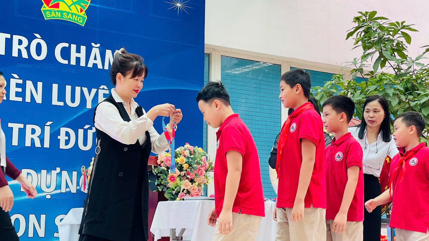 A person handing a medal to a group of children

AI-generated content may be incorrect.