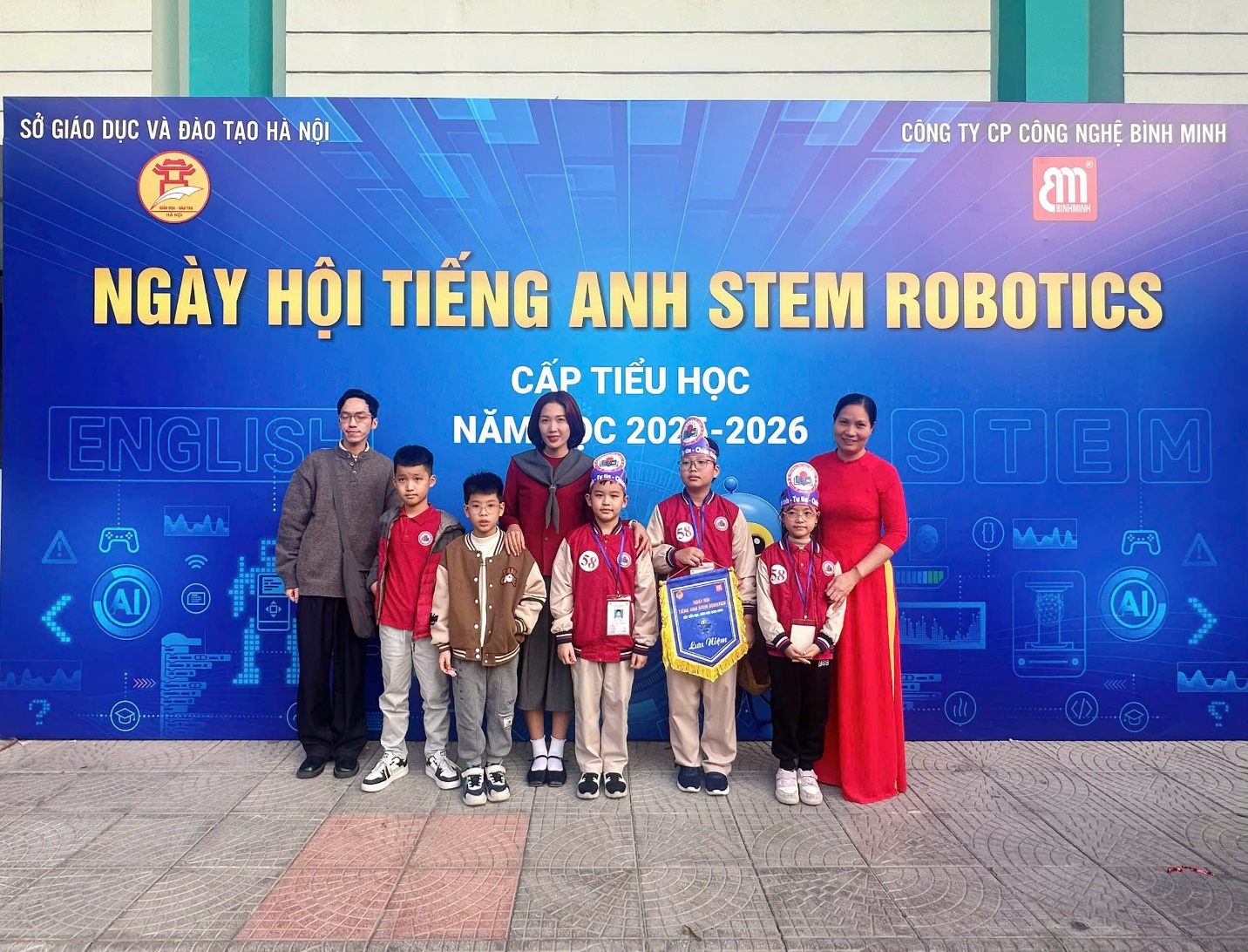 A group of people posing for a photo in front of a blue sign

AI-generated content may be incorrect.