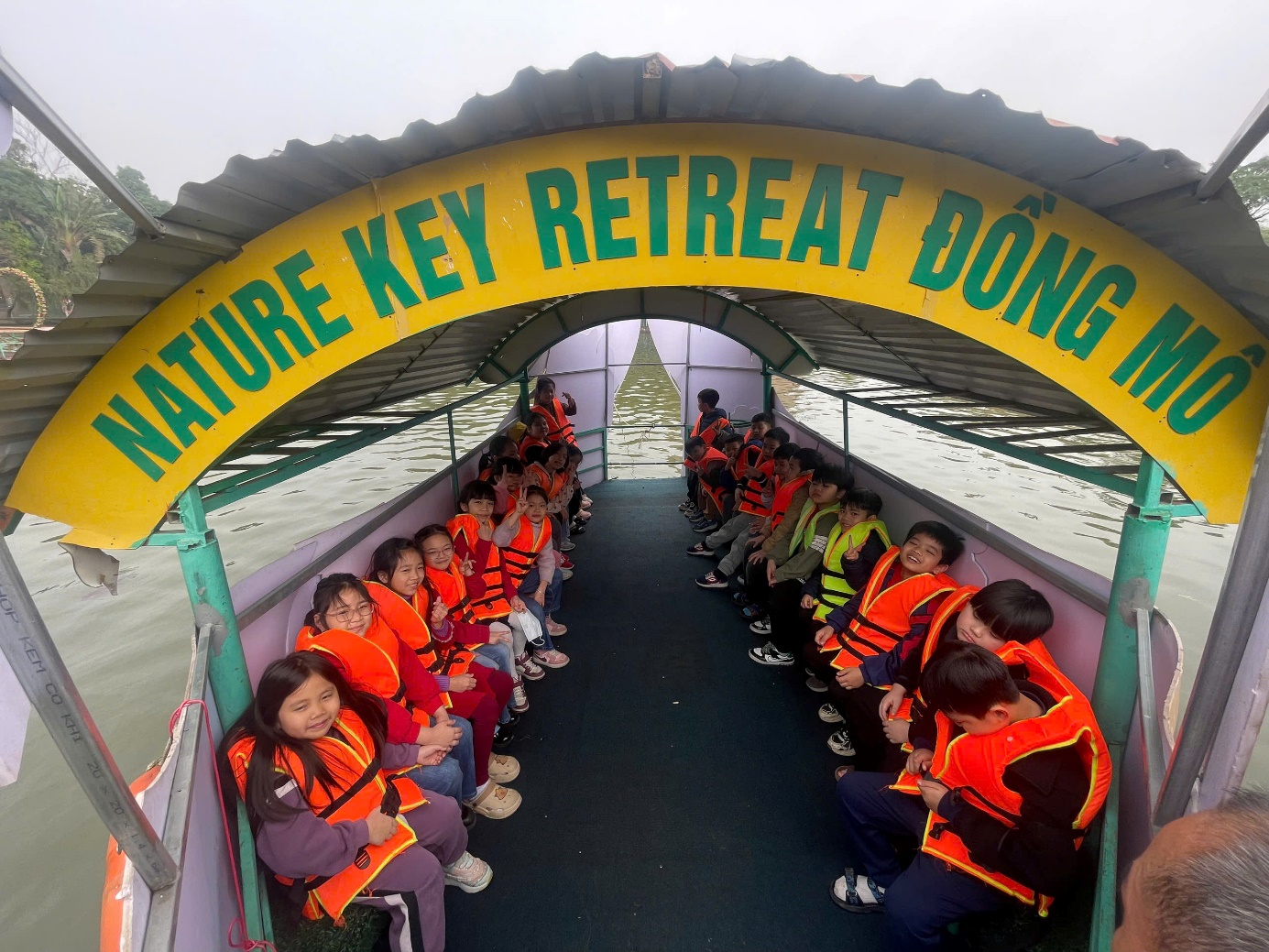 A group of children in orange vests sitting on a boat

AI-generated content may be incorrect.