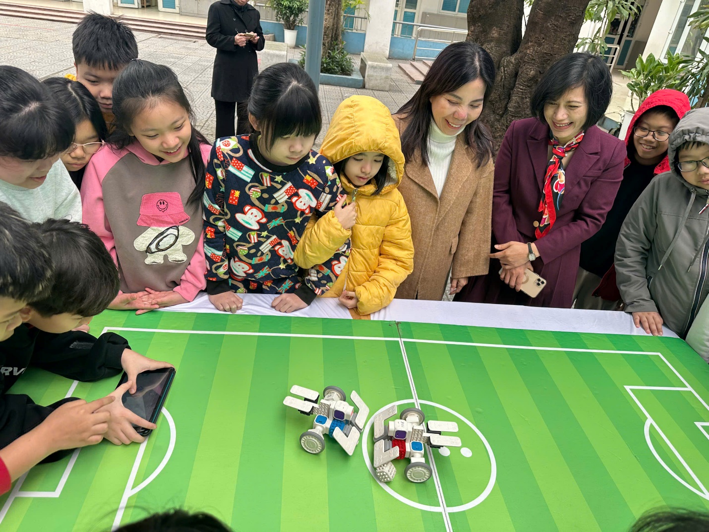 A group of people looking at a robot on a table

AI-generated content may be incorrect.
