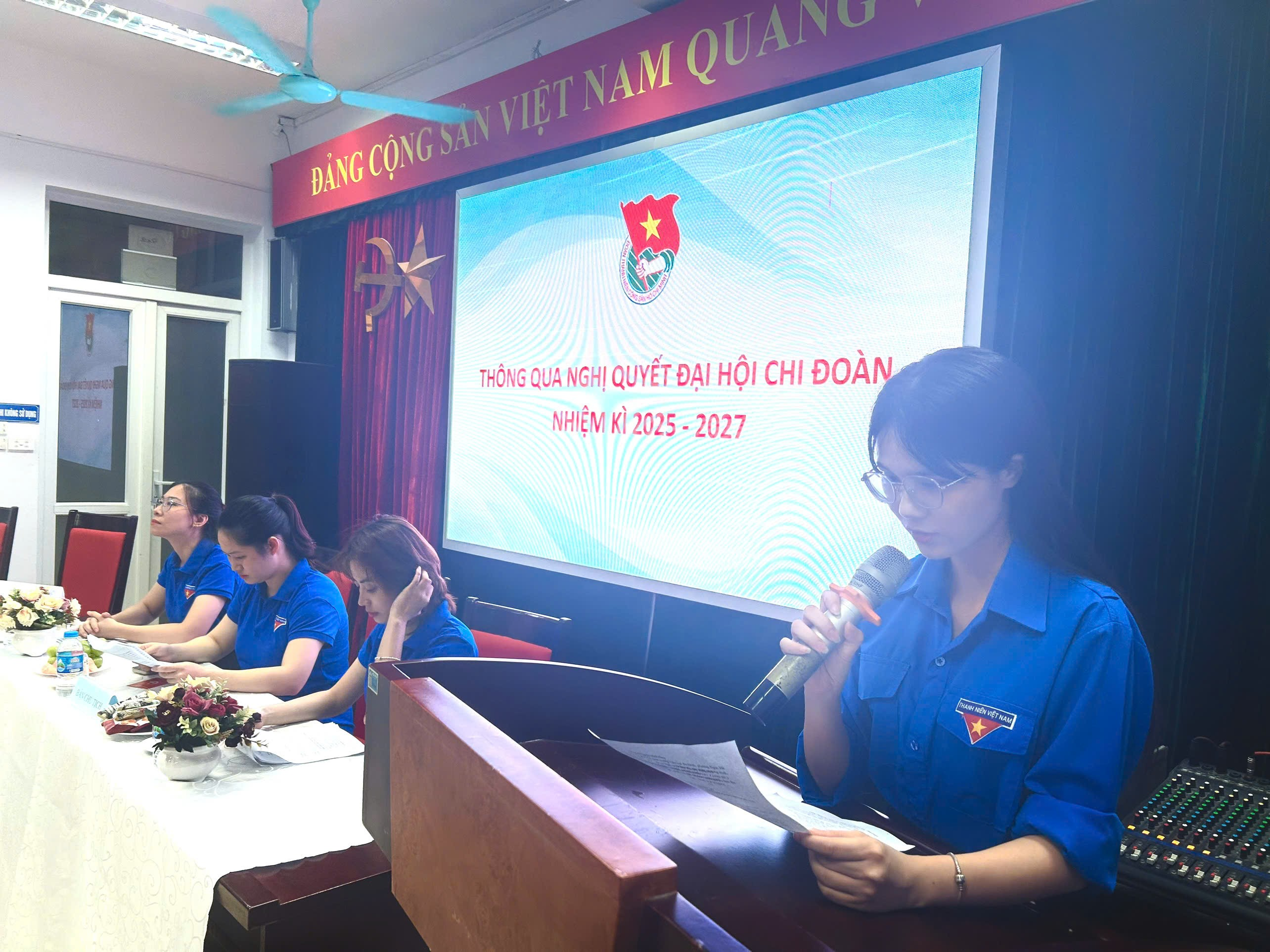 A person speaking into a microphone

Description automatically generated