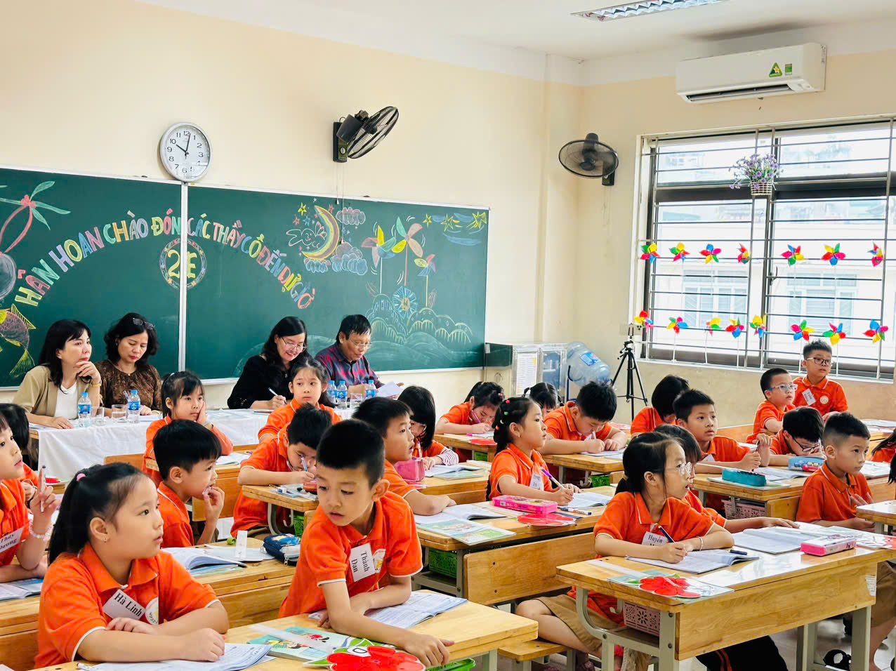 A group of children sitting at desks in a classroom

Description automatically generated