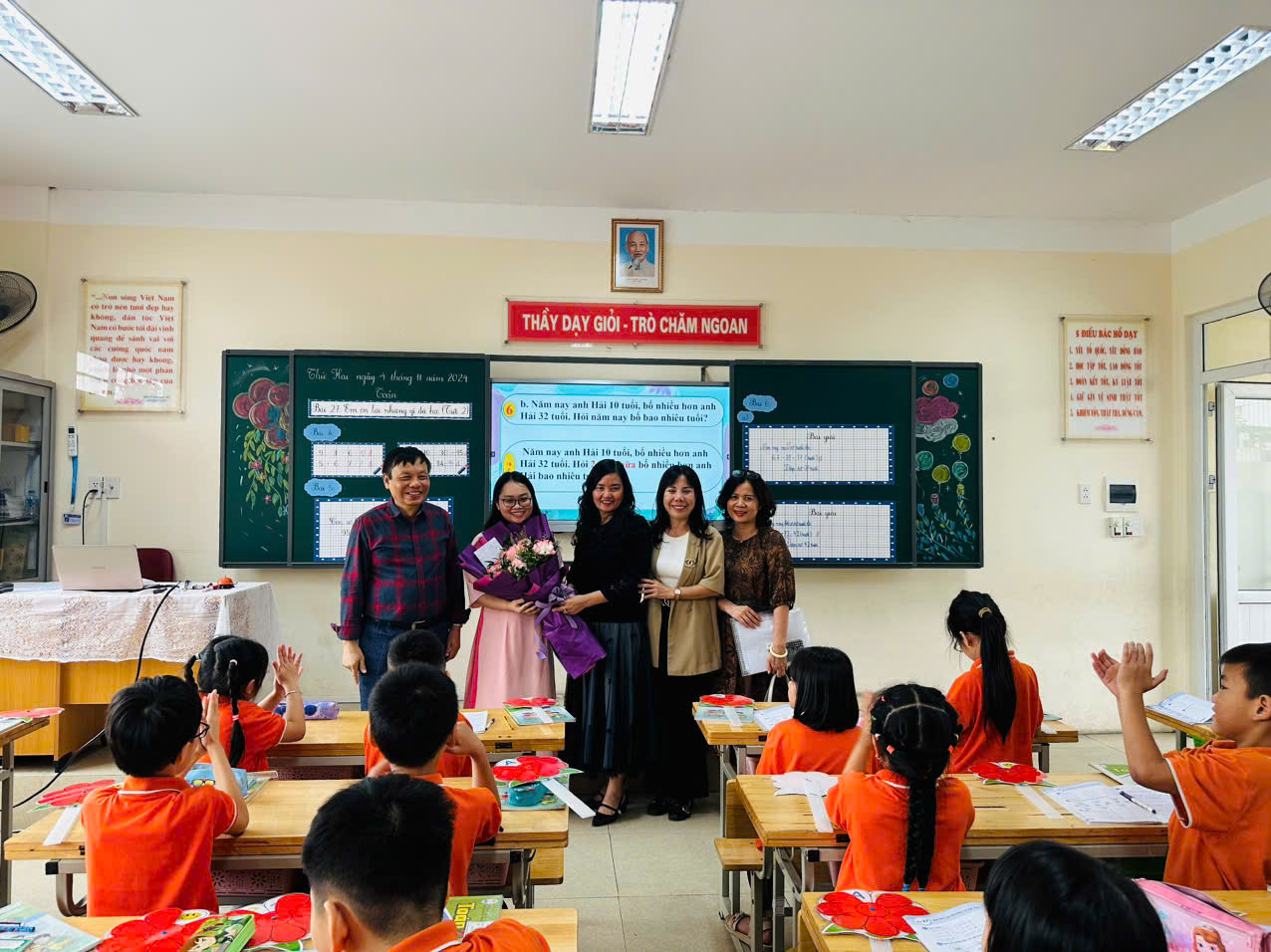 A group of people standing in a classroom

Description automatically generated