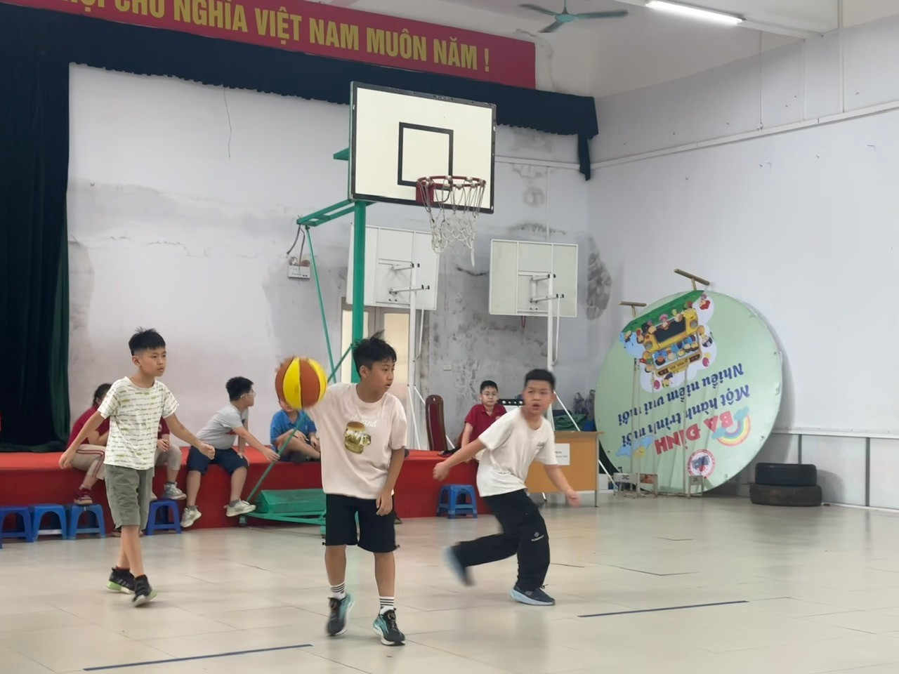 A group of boys playing basketball in a gym

Description automatically generated