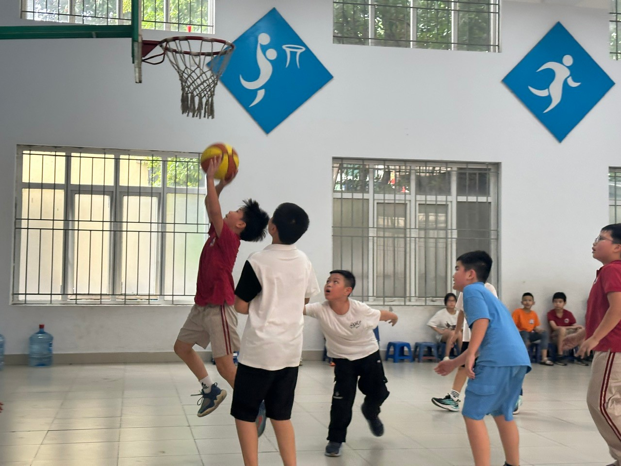 A group of kids playing basketball

Description automatically generated