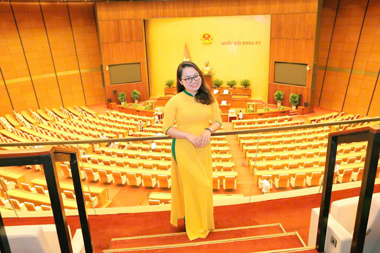 A person in a yellow dress standing on stairs in a room with rows of seats

AI-generated content may be incorrect.