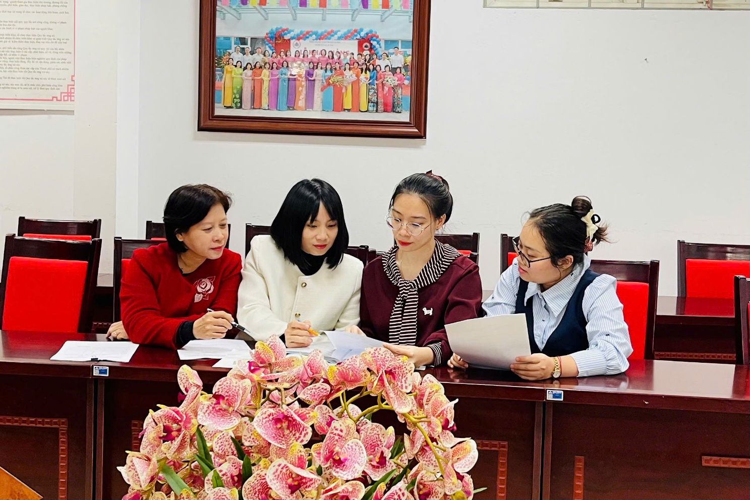 A group of women sitting at a desk

AI-generated content may be incorrect.