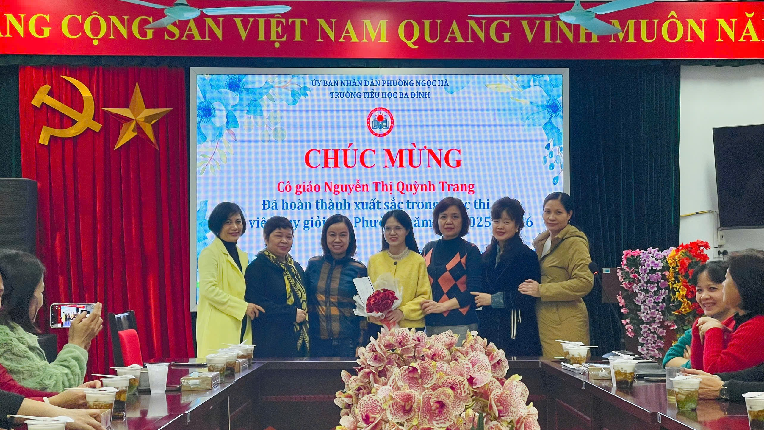 A group of women standing in front of a large screen

Description automatically generated