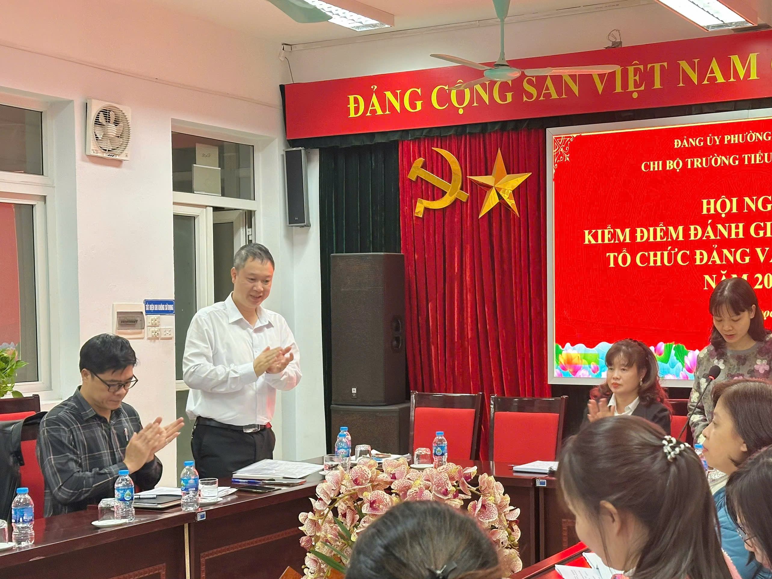 A person standing in front of a group of people

Description automatically generated