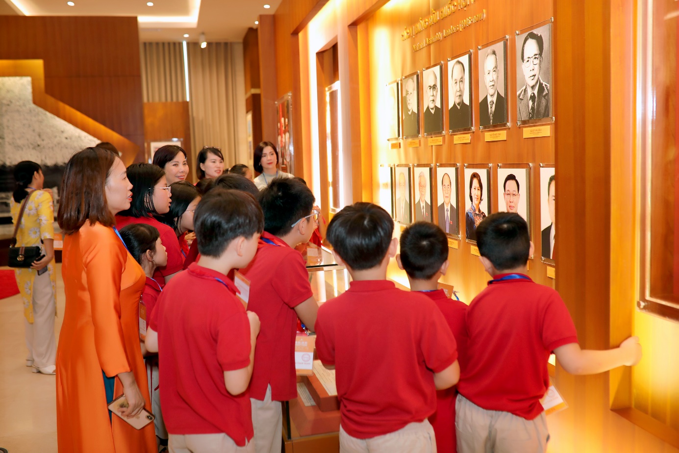 A group of children looking at a display of portraits

Description automatically generated