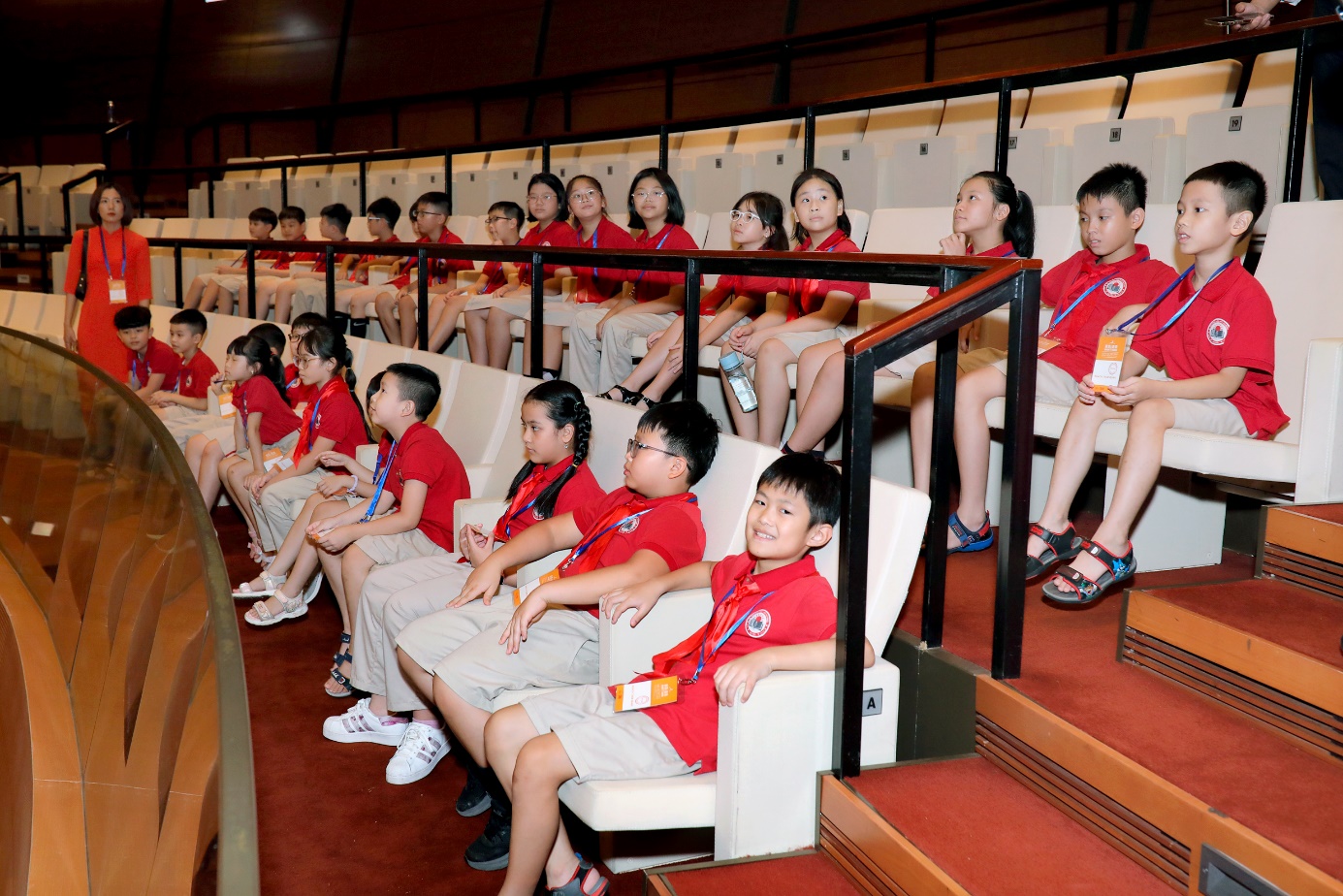 A group of children sitting in a row

Description automatically generated