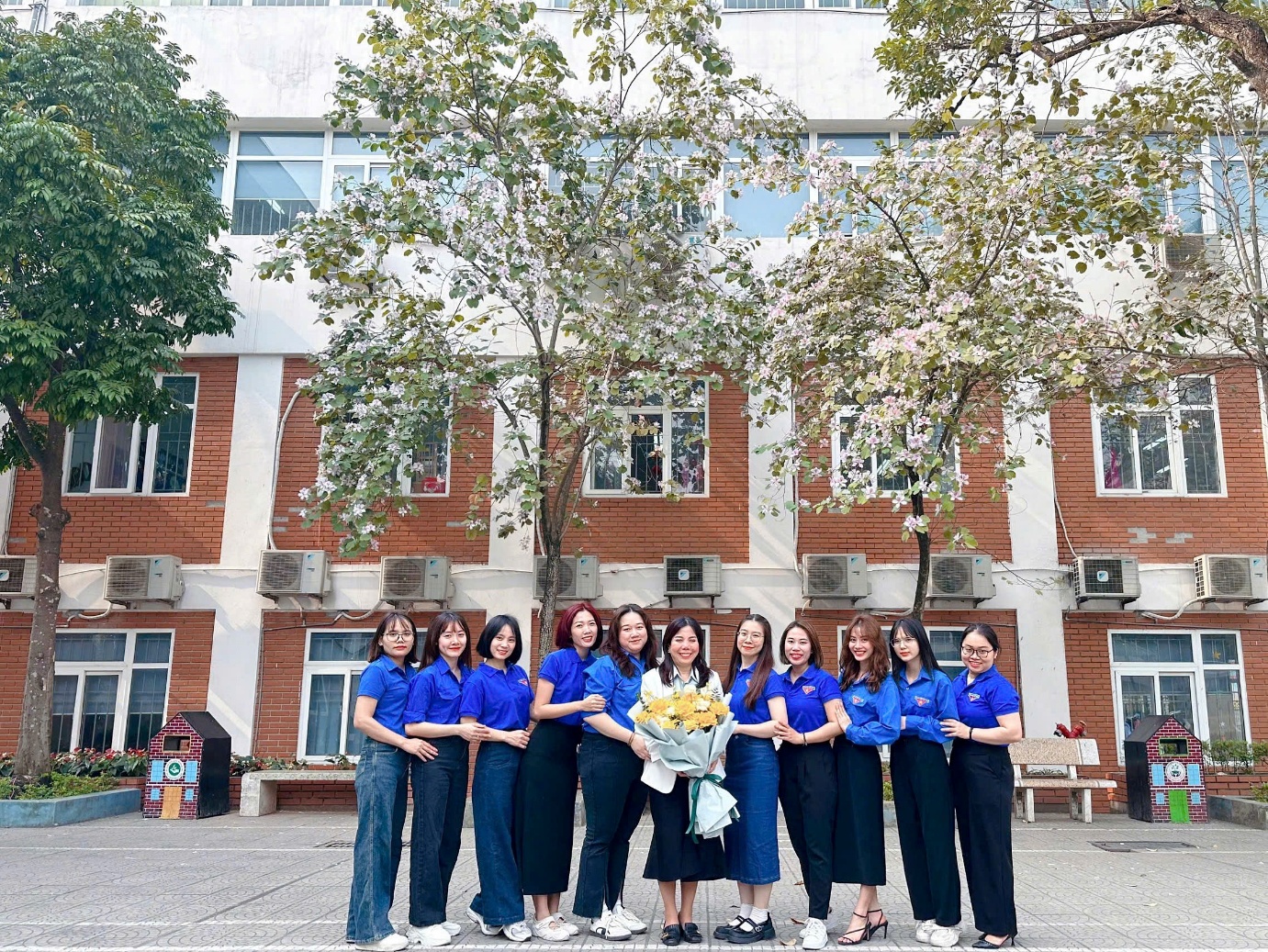 A group of women in blue shirts standing in front of a building

AI-generated content may be incorrect.