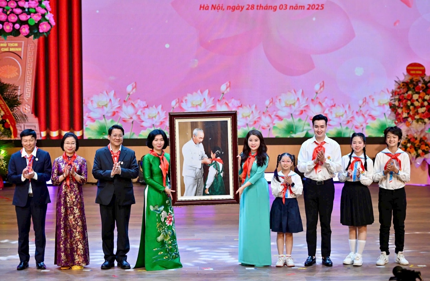 A group of people standing on a stage holding a picture

AI-generated content may be incorrect.