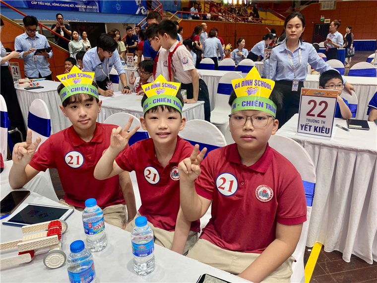 A group of boys sitting at tables with paper crowns

Description automatically generated