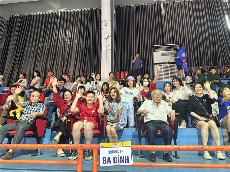 A group of people sitting in a stadium

Description automatically generated