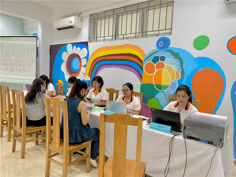 A group of people sitting at a table with laptops

Description automatically generated